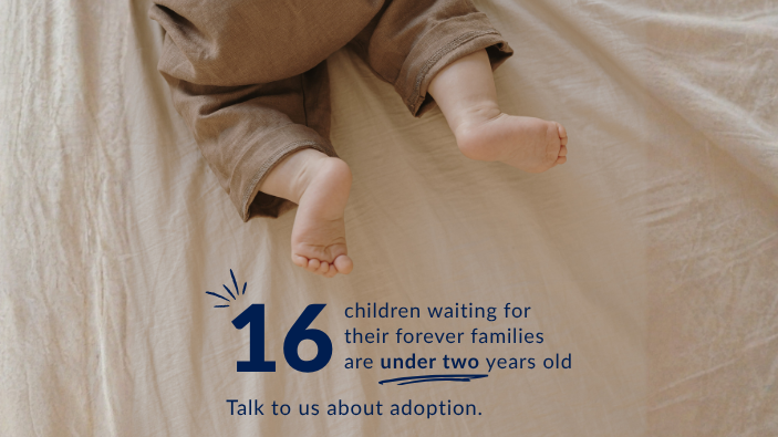 Infant lying on a bed with text stating that 16 children waiting for their forever families are under two years old and encouraging people to talk about adoption.