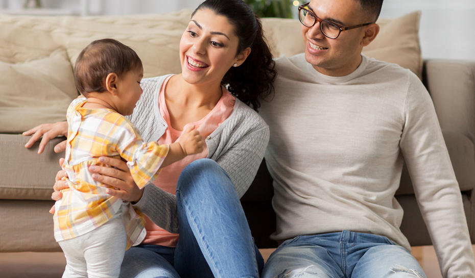 Couple smiling and holding a baby